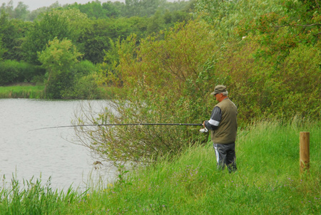 pecheur à la ligne habillé en vert